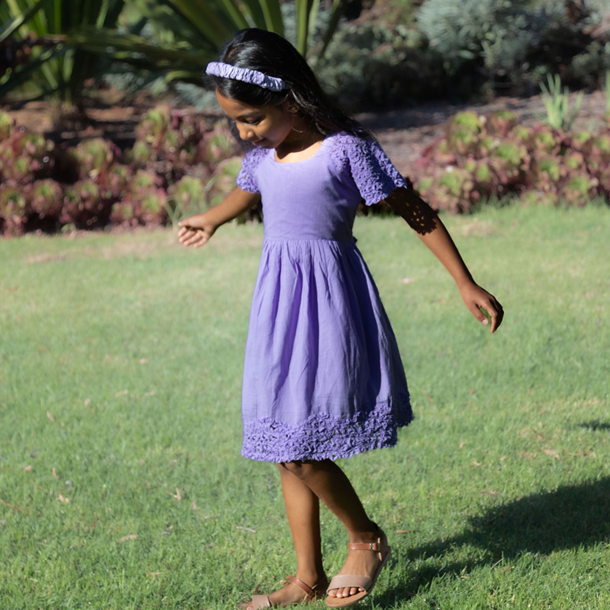 Girl wearing cotton dark violet textured dress in nature