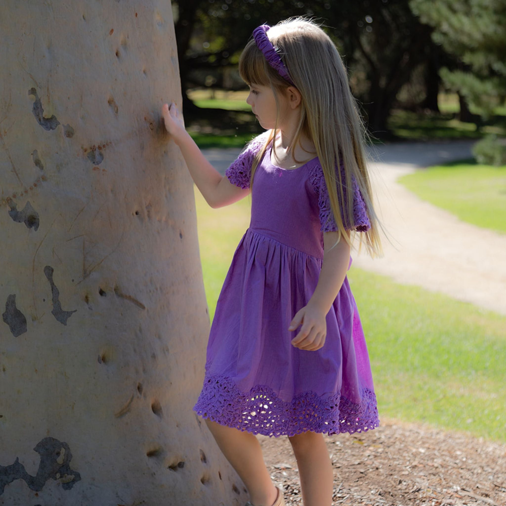 Girl in nature wearing purple cotton textured dress