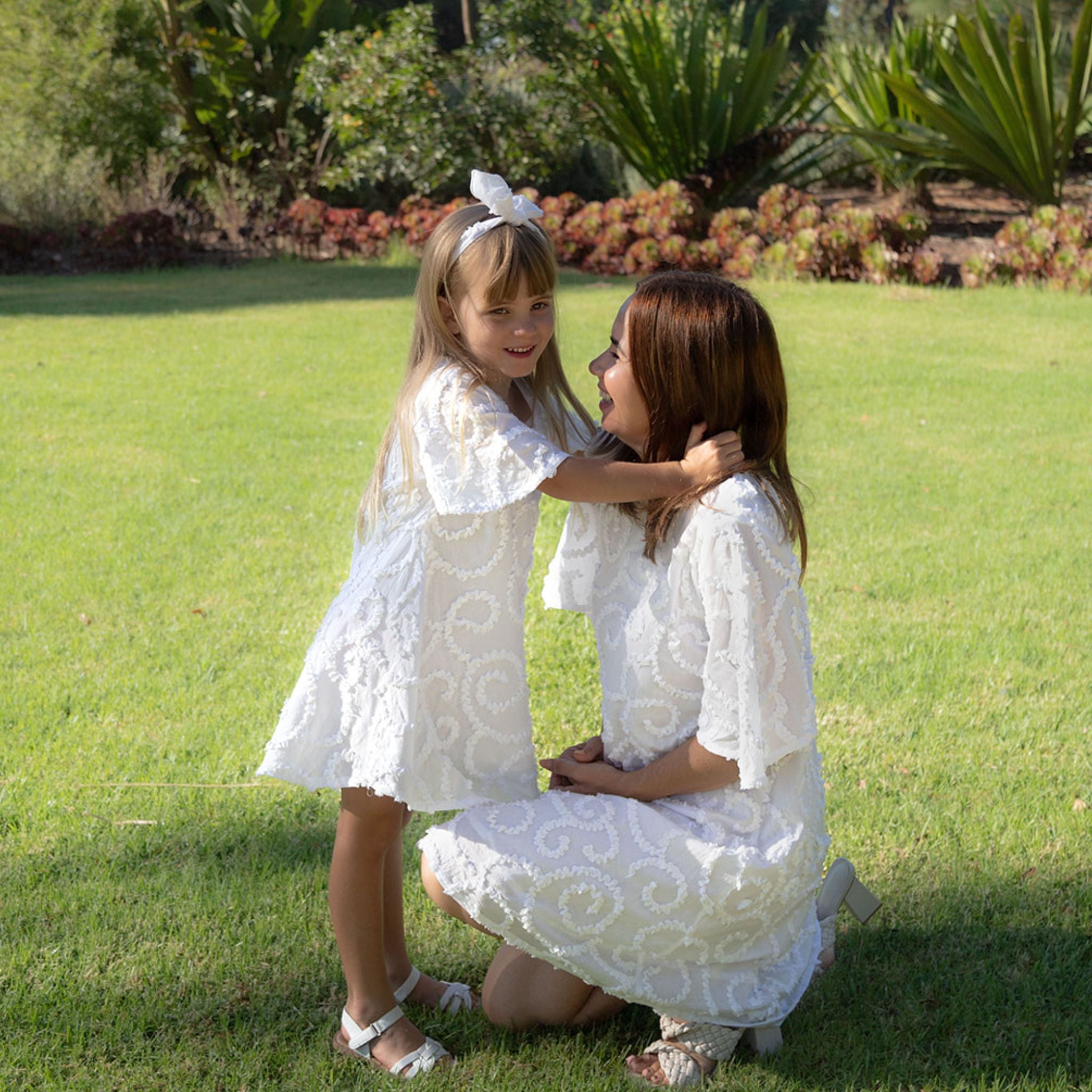 Mother daughter wearing white texture cotton dress outdoors