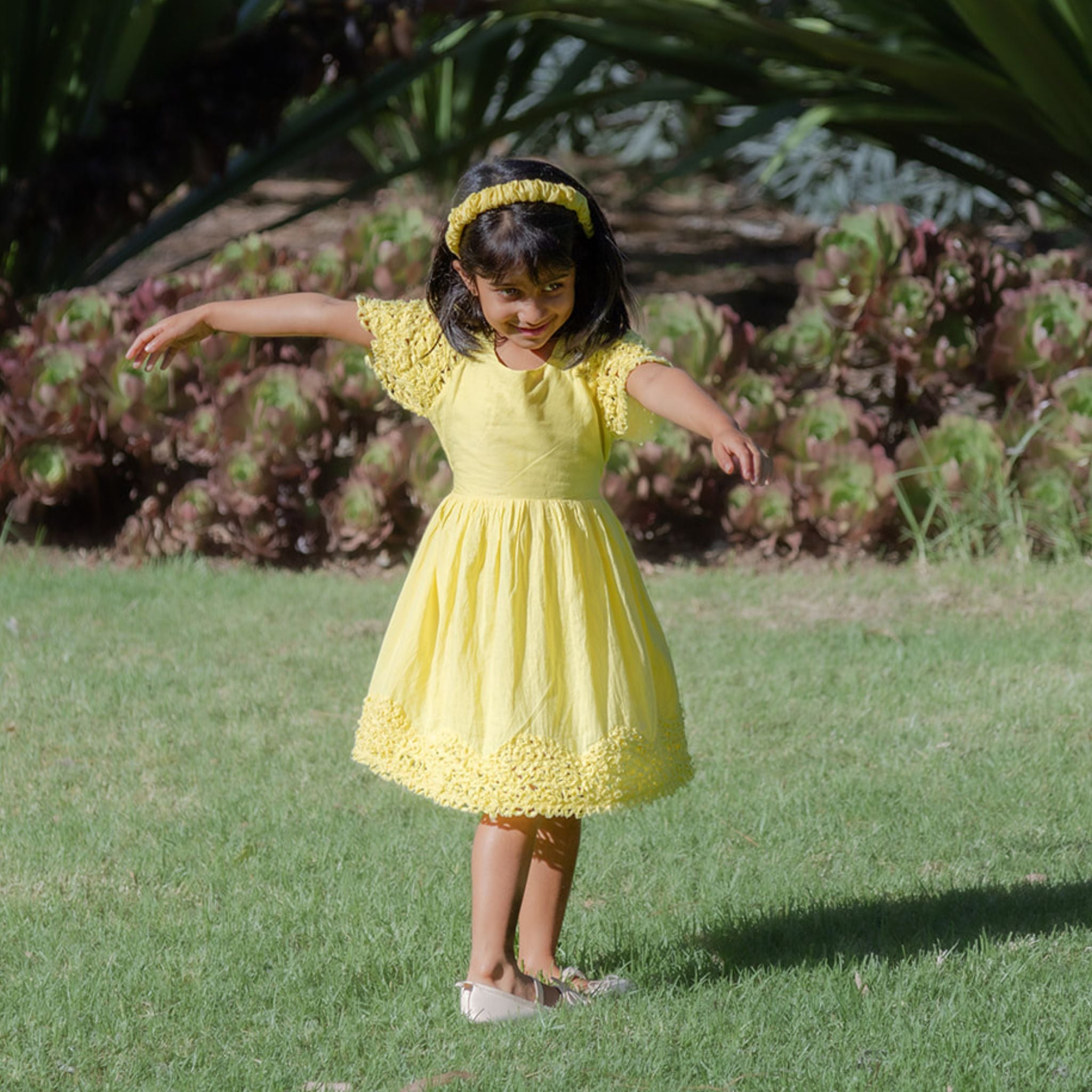 Girl wearing yellow cotton textured dress in nature